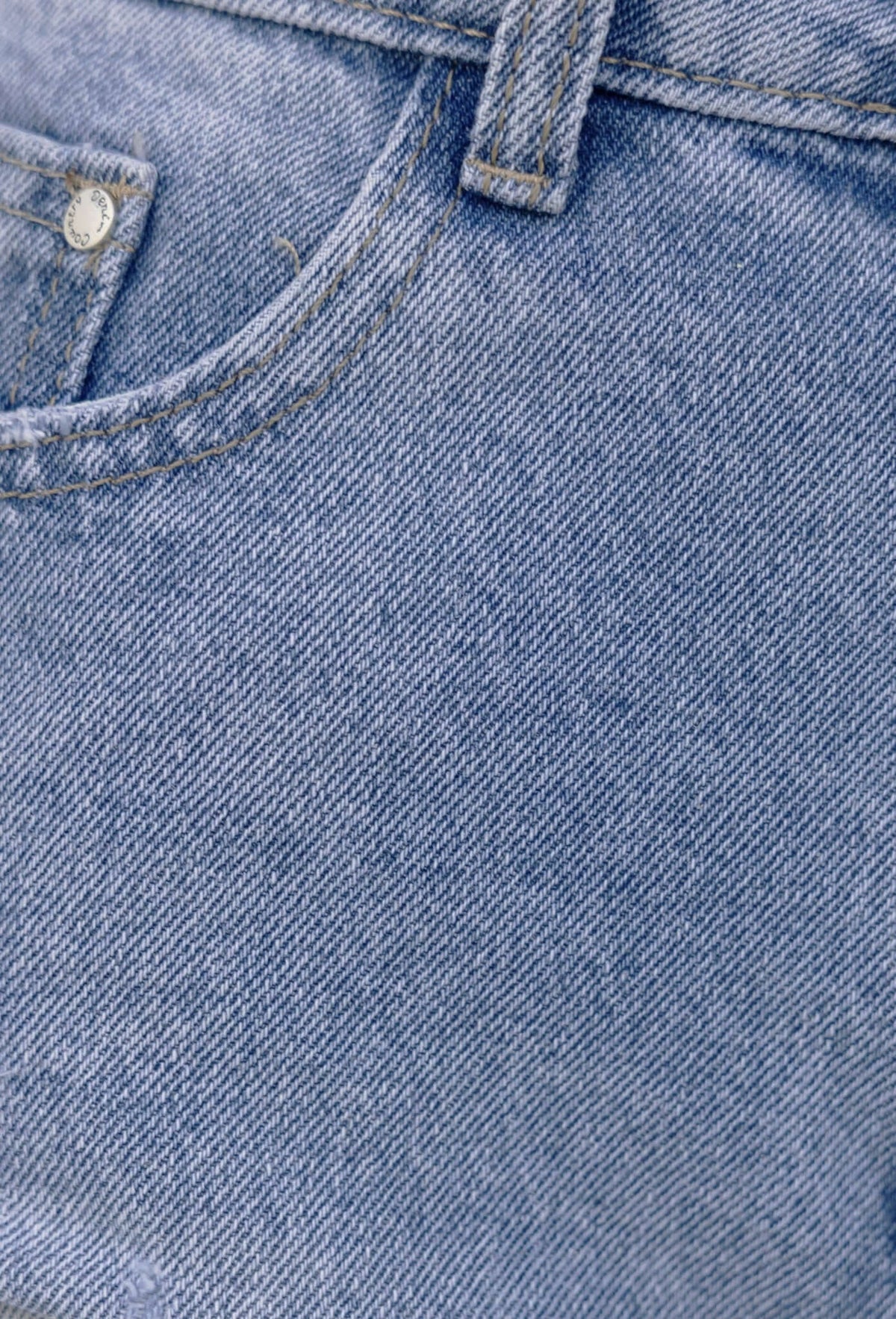 Close-up of Jardin Denim Shorts showing distressed rip details and raw hemline in light blue denim.