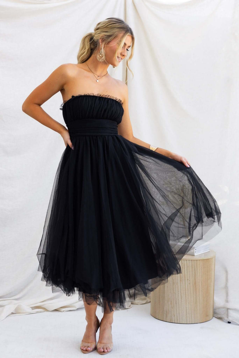 Model wearing Sweetest Treat Maxi Dress, a black strapless tulle overlay dress with a flowy skirt, perfect for special occasions.