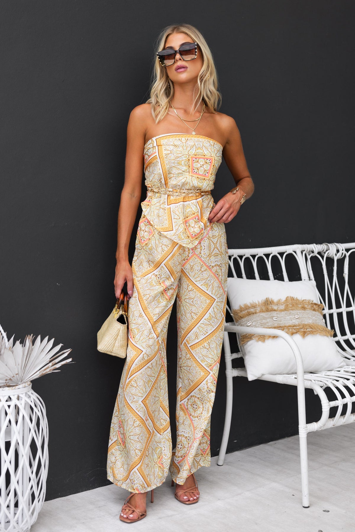 Vivid Top featuring an abstract print, strapless design, and adjustable tie at back with gold hardware, worn by a model.