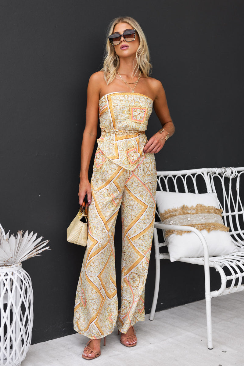 Vivid Top featuring an abstract print, strapless design, and adjustable tie at back with gold hardware, worn by a model.