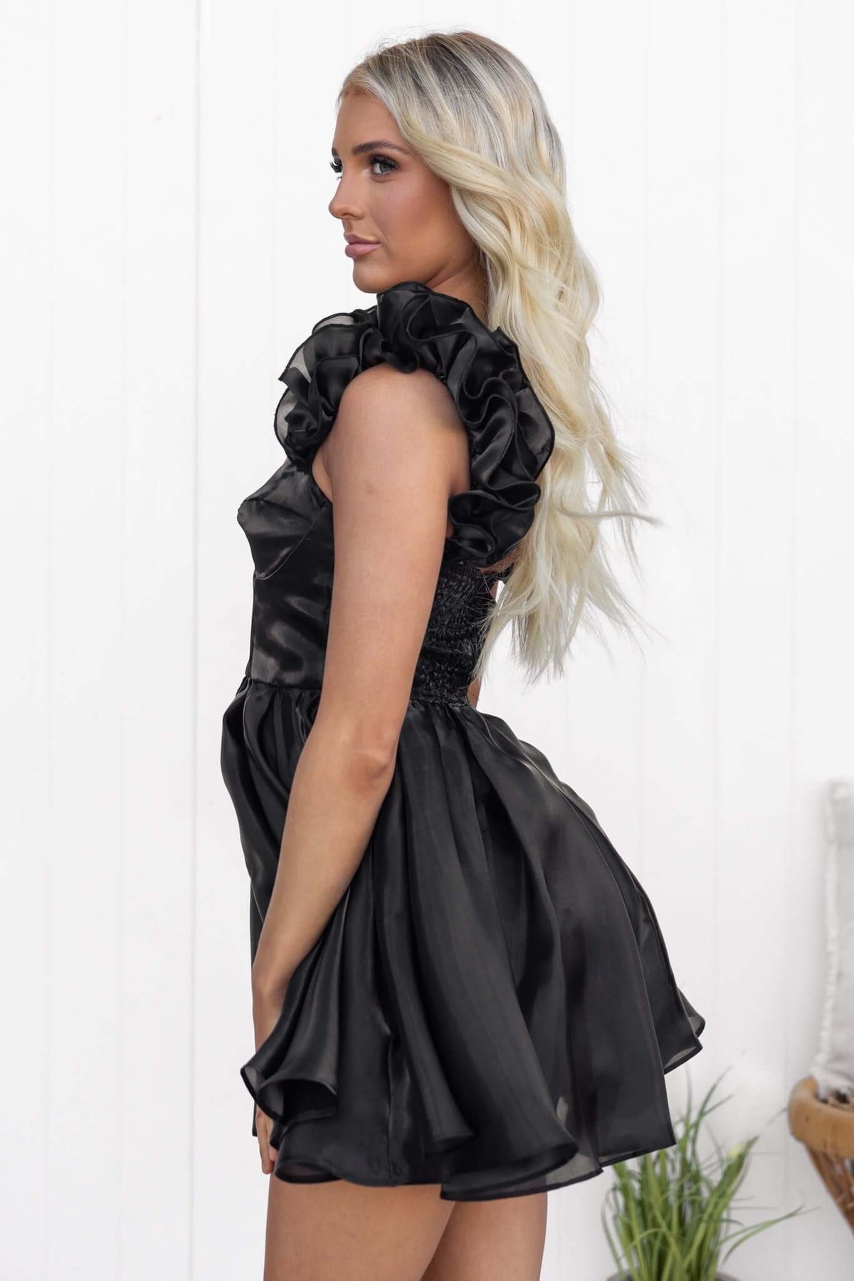 Ermia Dress in black featuring ruffle straps, elastic back, and a flared chiffon skirt.