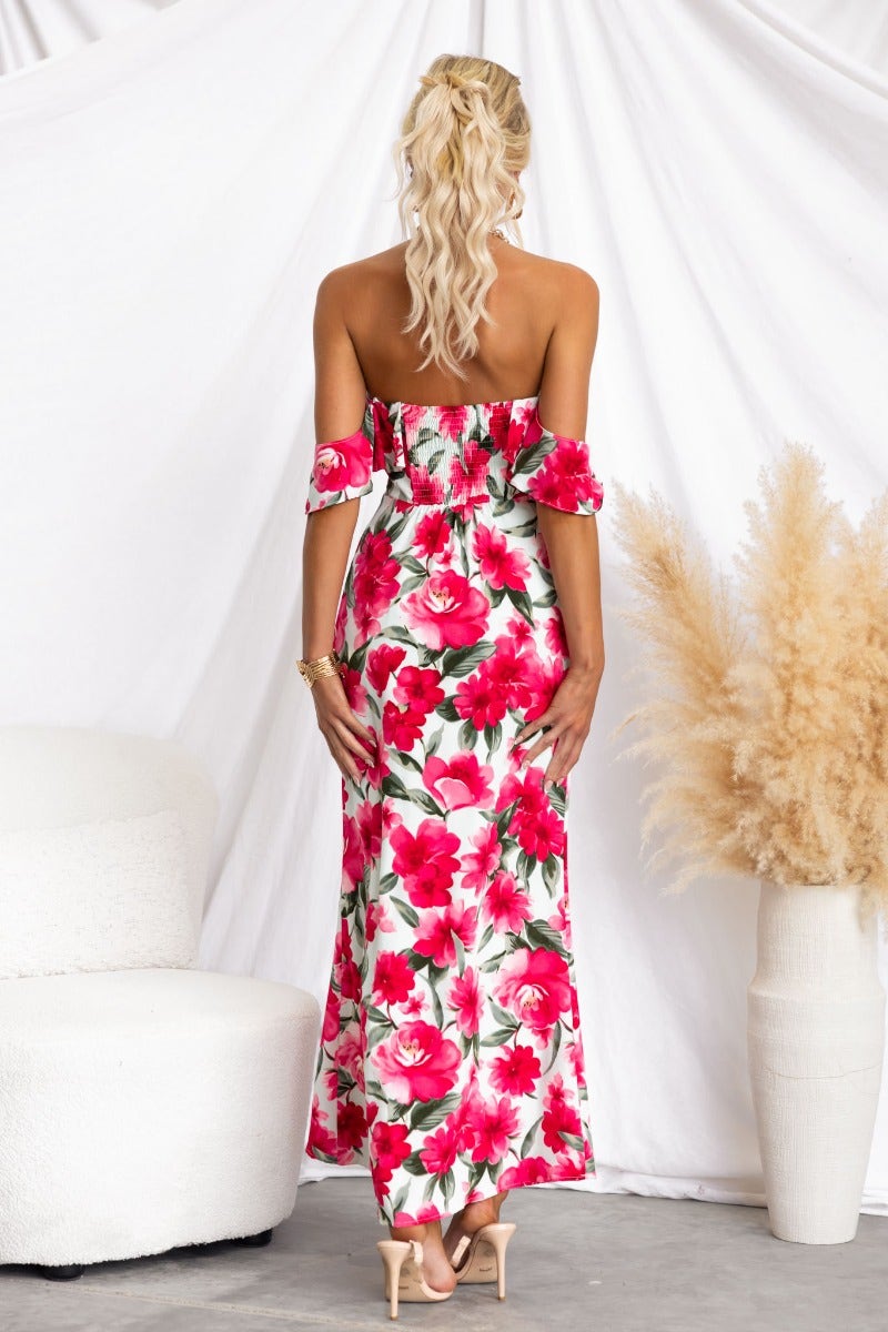 Back view of a floral print off-shoulder maxi dress with tie detail and fitted bodice, displaying vibrant pink roses.