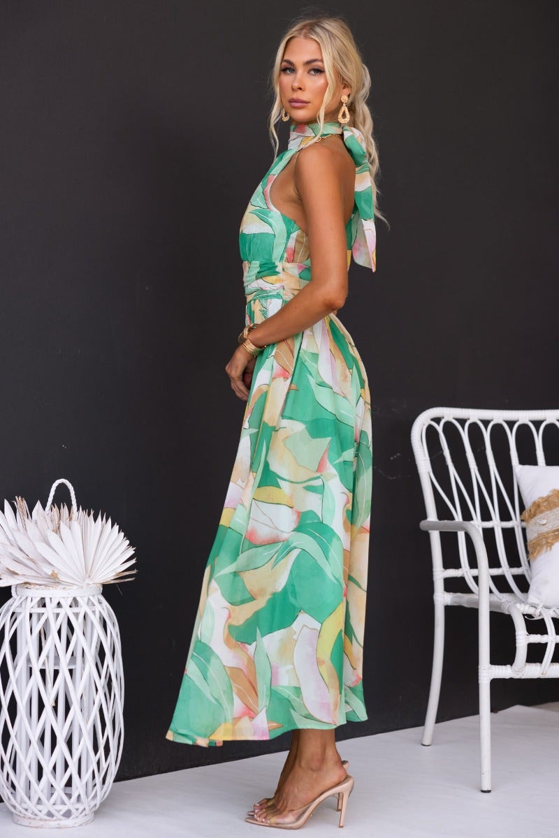 Model wearing a floral print Little Things Maxi Dress with high tie neckline and invisible zip, styled in a chic setting.