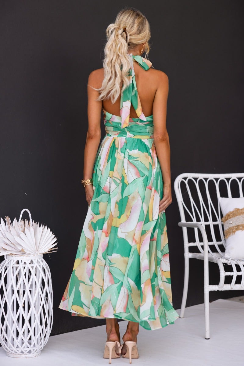 Back view of the Little Things floral print maxi dress with high tie neckline and flowing skirt.