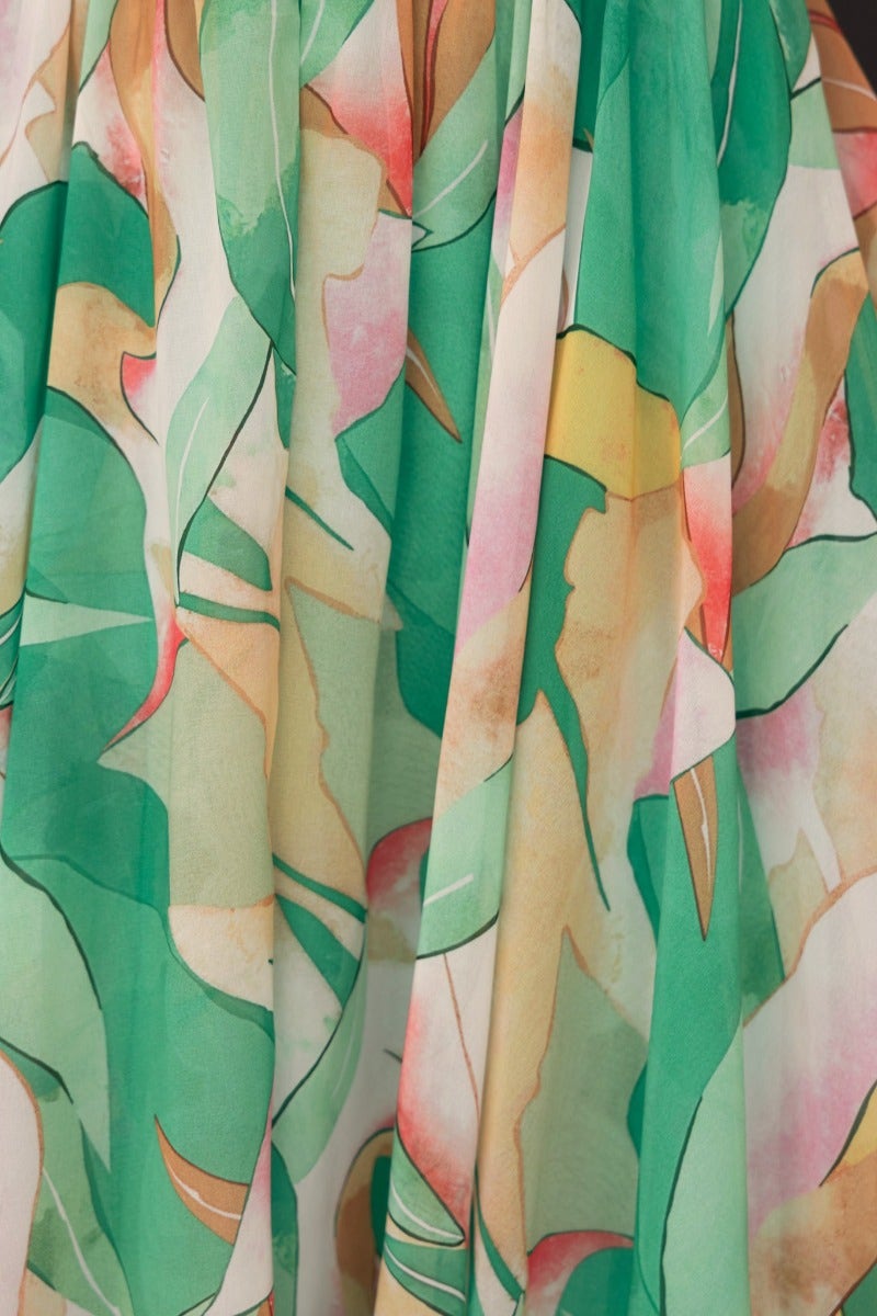 Close-up of floral print fabric showcasing vibrant green leaves and soft pastel colors, ideal for the Little Things Maxi Dress.