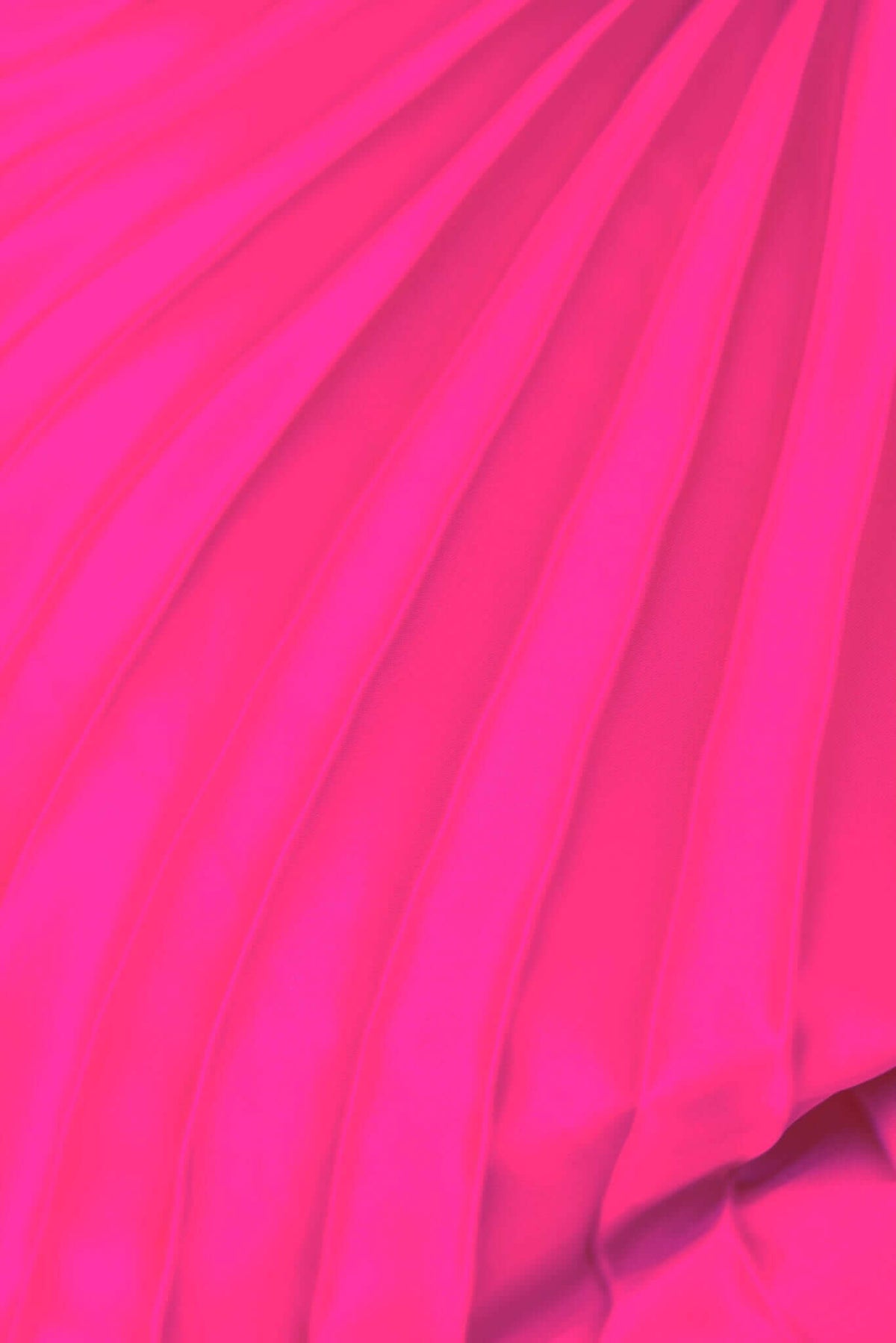 Close-up of vibrant pink accordion pleat fabric showcasing intricate texture for fashion design.