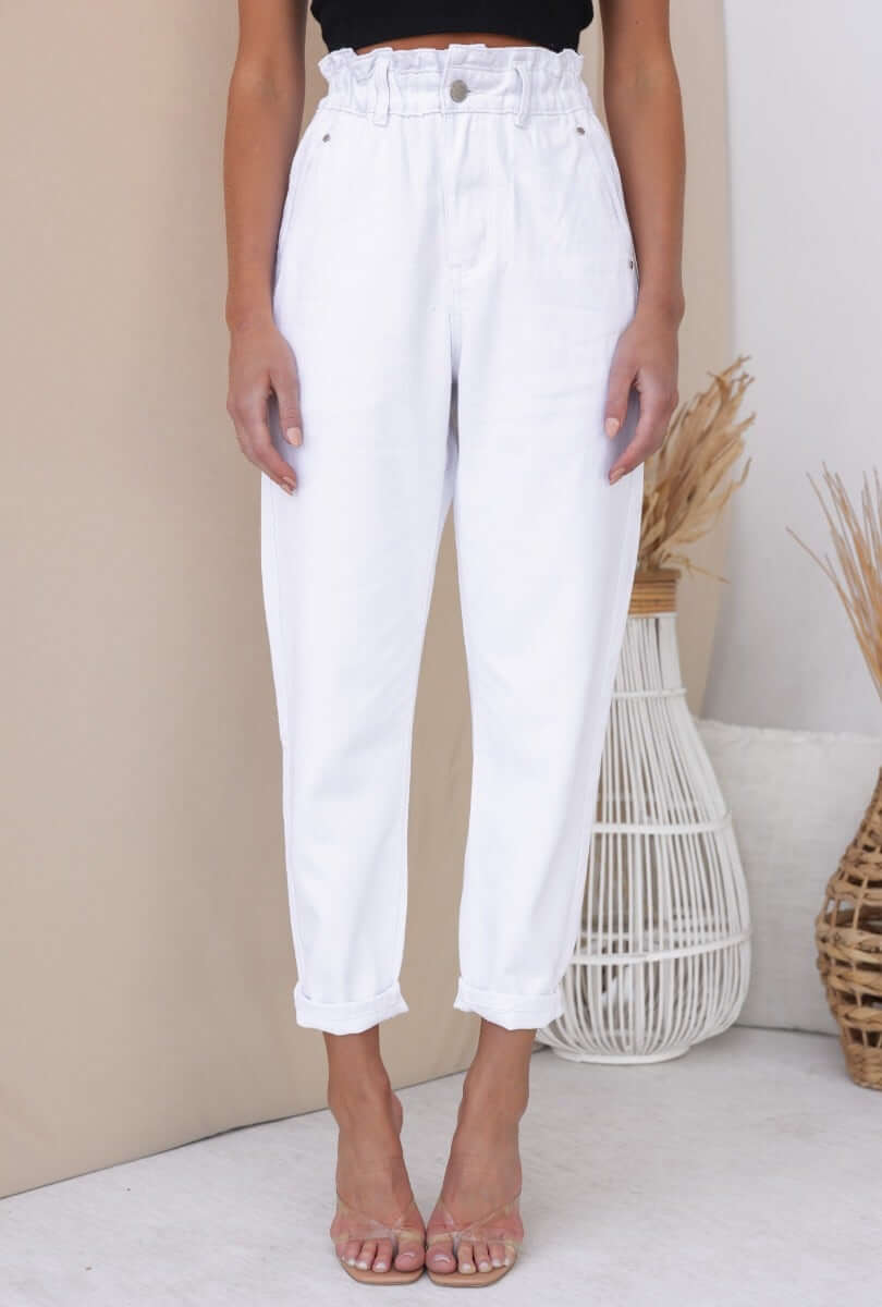 Cameron Paperbag Jeans in white with elastic waistband and pockets, styled with a relaxed fit and rolled cuffs.