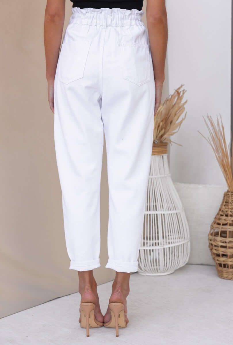 Back view of Cameron Paperbag Jeans with elastic waistband, featuring pockets and a relaxed fit, styled with heels.