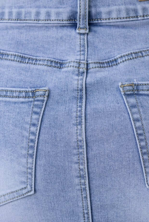 Close-up of the back of a Jaya denim skirt, showcasing the mid-low waist fit and pockets in light blue denim.