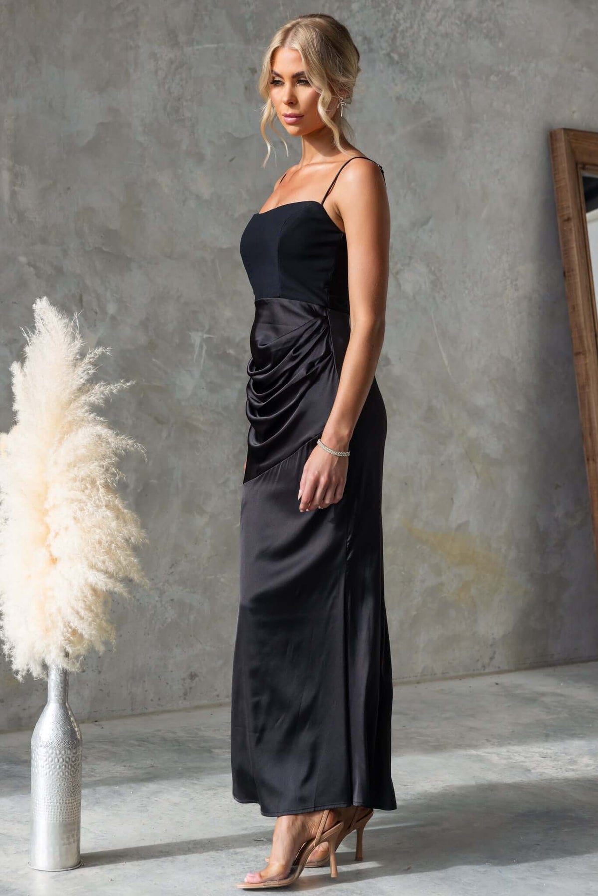 Atheni Maxi Dress in black featuring adjustable straps, satin skirt, and gathered detailing, perfect for special occasions.