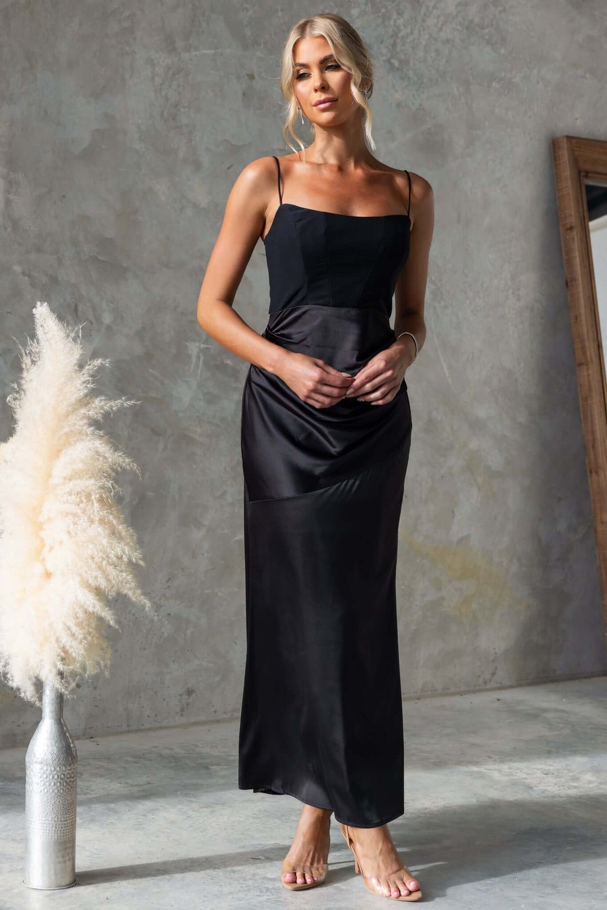 Model wearing Amaroso Bridal Atheni Maxi Dress with adjustable straps and satin skirt, posed in a stylish setting.