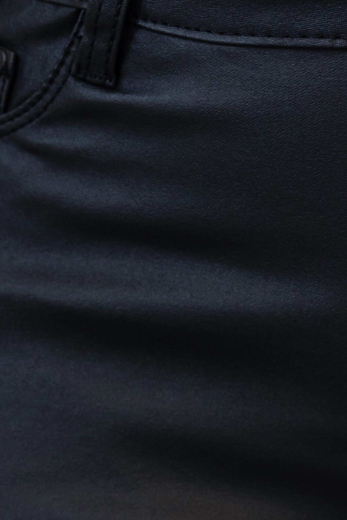 Close-up of Luscious black faux leather pants showcasing the smooth texture and firm stretch fabric.