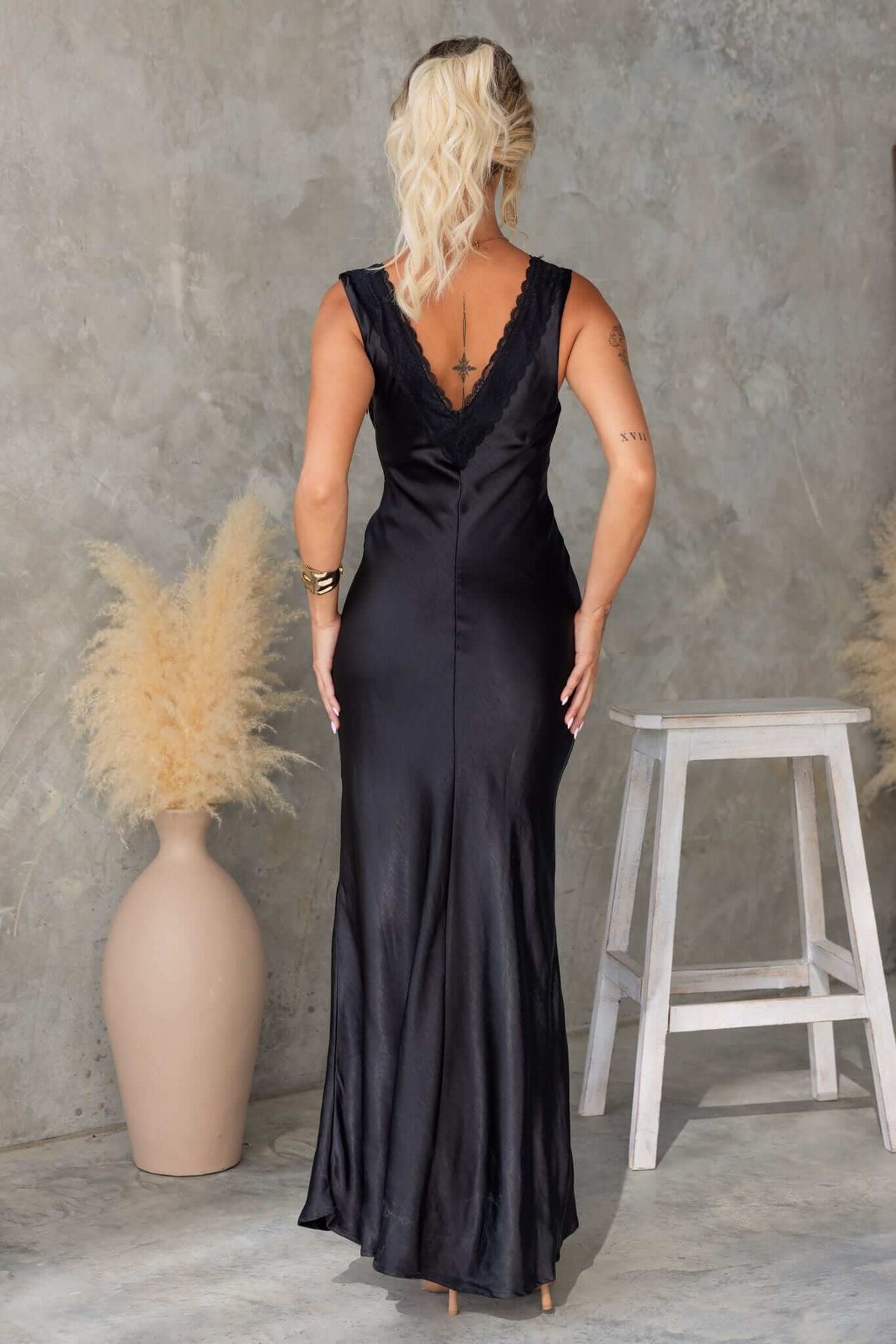 Back view of a black Locust Maxi Dress with a V-neckline and flared skirt.