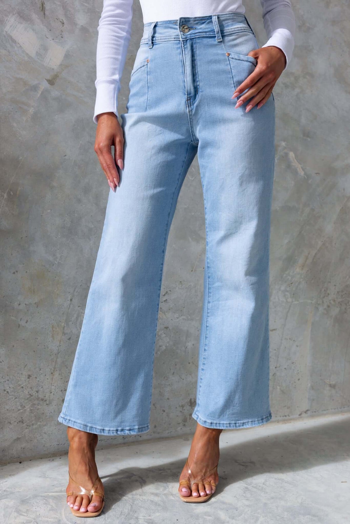 Blanca Jeans in light blue with wide legs, mid-high waist fit, and front & back pockets, modeled by a woman.