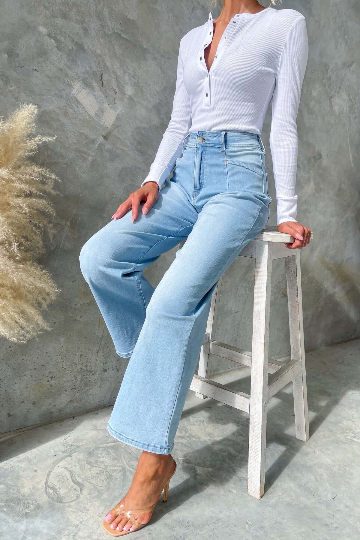 Woman wearing Blanca Jeans with wide legs and a mid-high waist fit, styled with a white long-sleeve top.