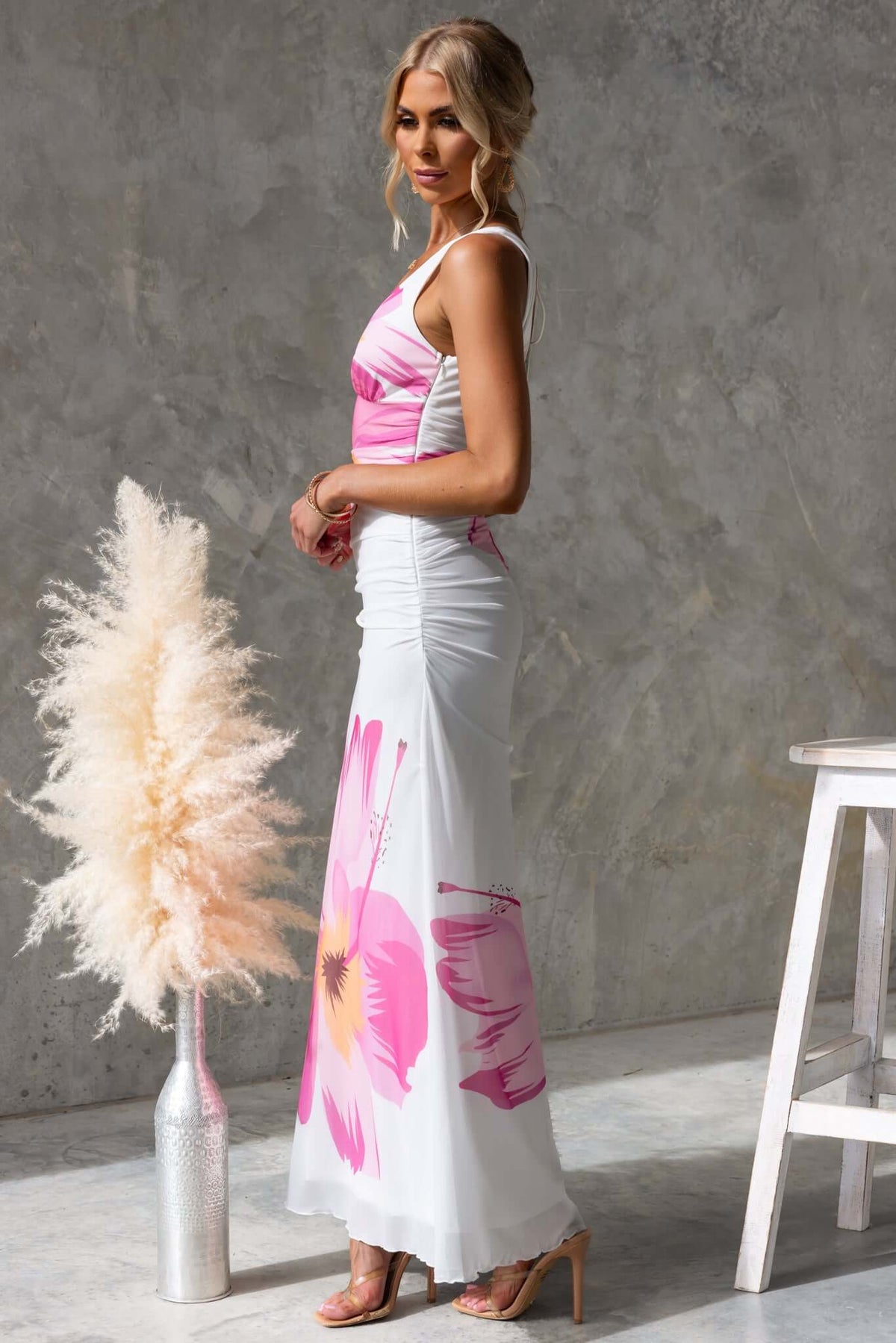 Model showcasing Blax Maxi Dress with floral design, V-neck, and tie-back, perfect for stylish summer outings.