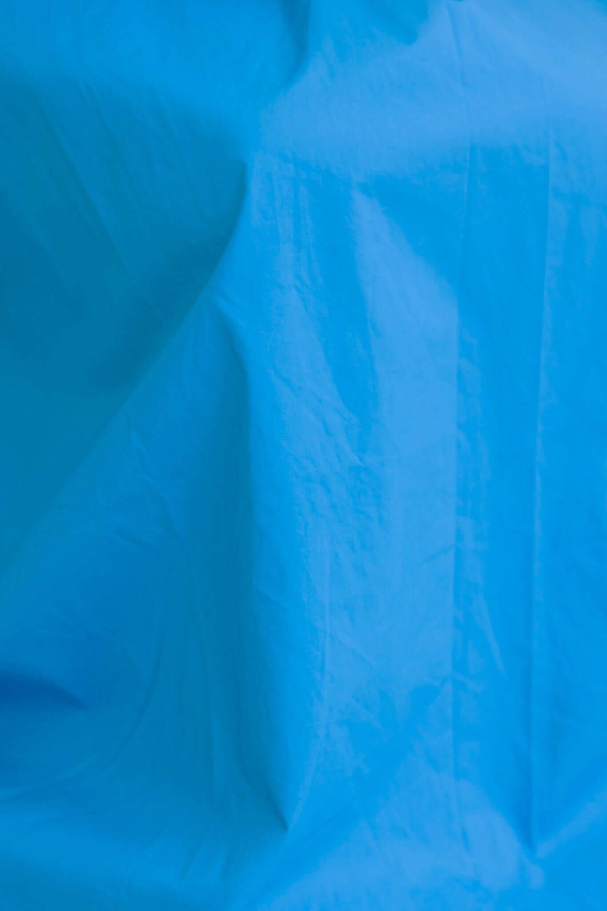 Close-up of textured blue fabric, showcasing a smooth cotton look and feel.