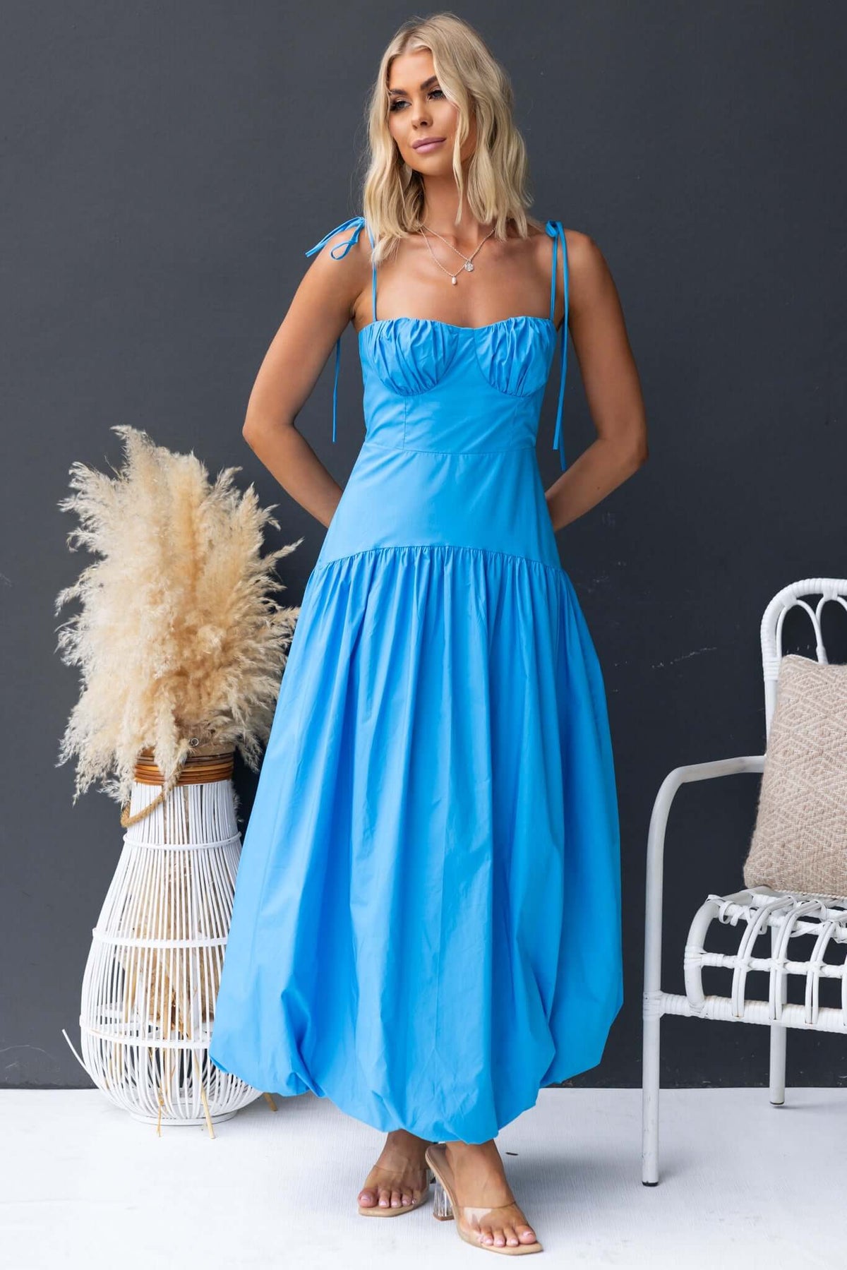 Model wearing a Bonisa Maxi Dress in bright blue with tie straps and a flowy skirt, styled against a neutral backdrop.