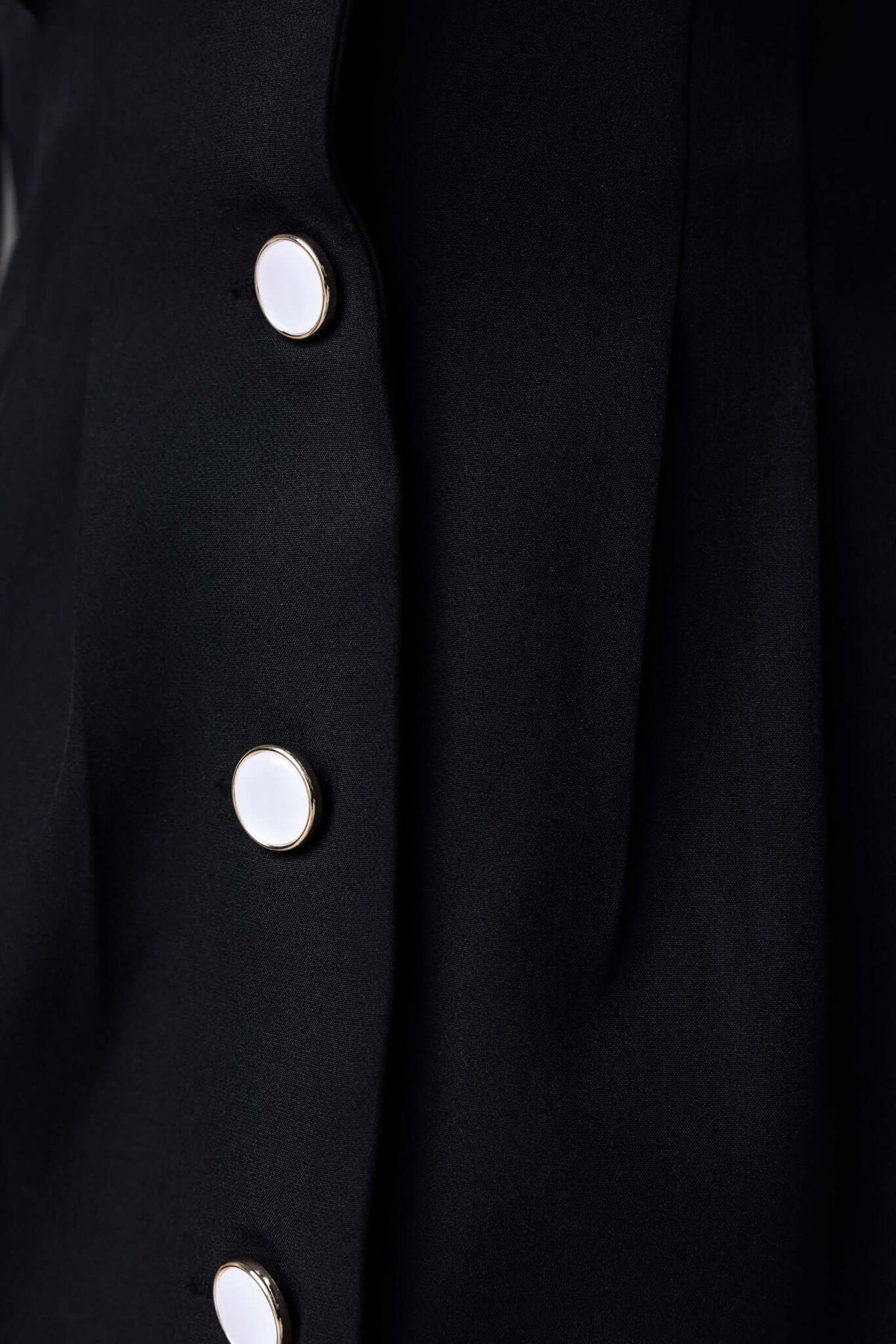 Close-up of Brookings Dress showing button-up front and shoulder pads detail on black fabric.