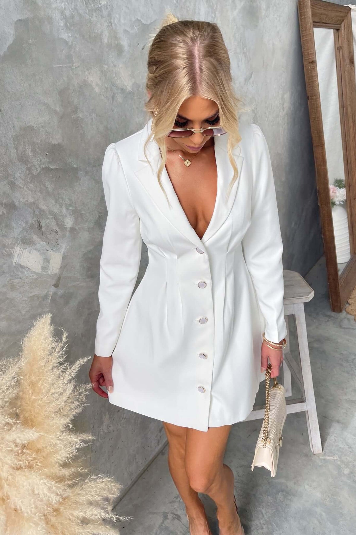 Brookings Dress featuring a V-neckline and shoulder pads, styled with a button-up front, perfect for a chic look.