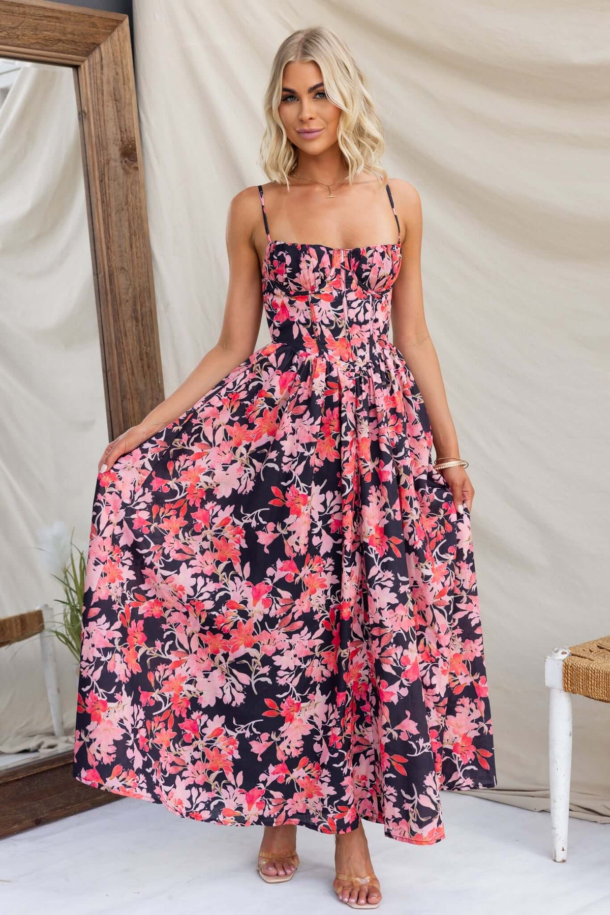 Model wearing Burkes Midi Dress with floral print, adjustable straps, and a flowing skirt, perfect for summer occasions.