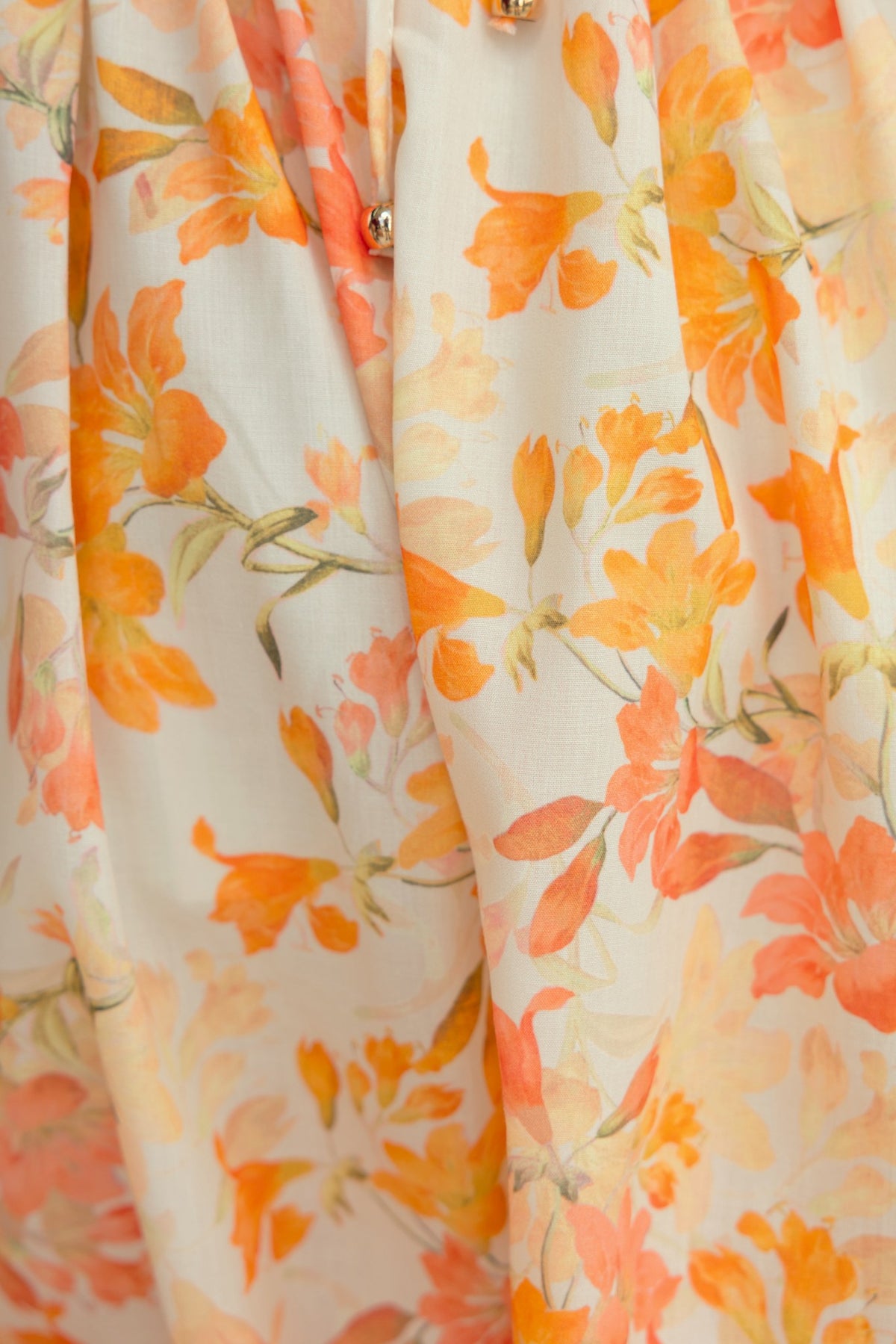 Close-up of Burkes Midi Dress featuring a floral pattern in orange and peach tones on a light background.