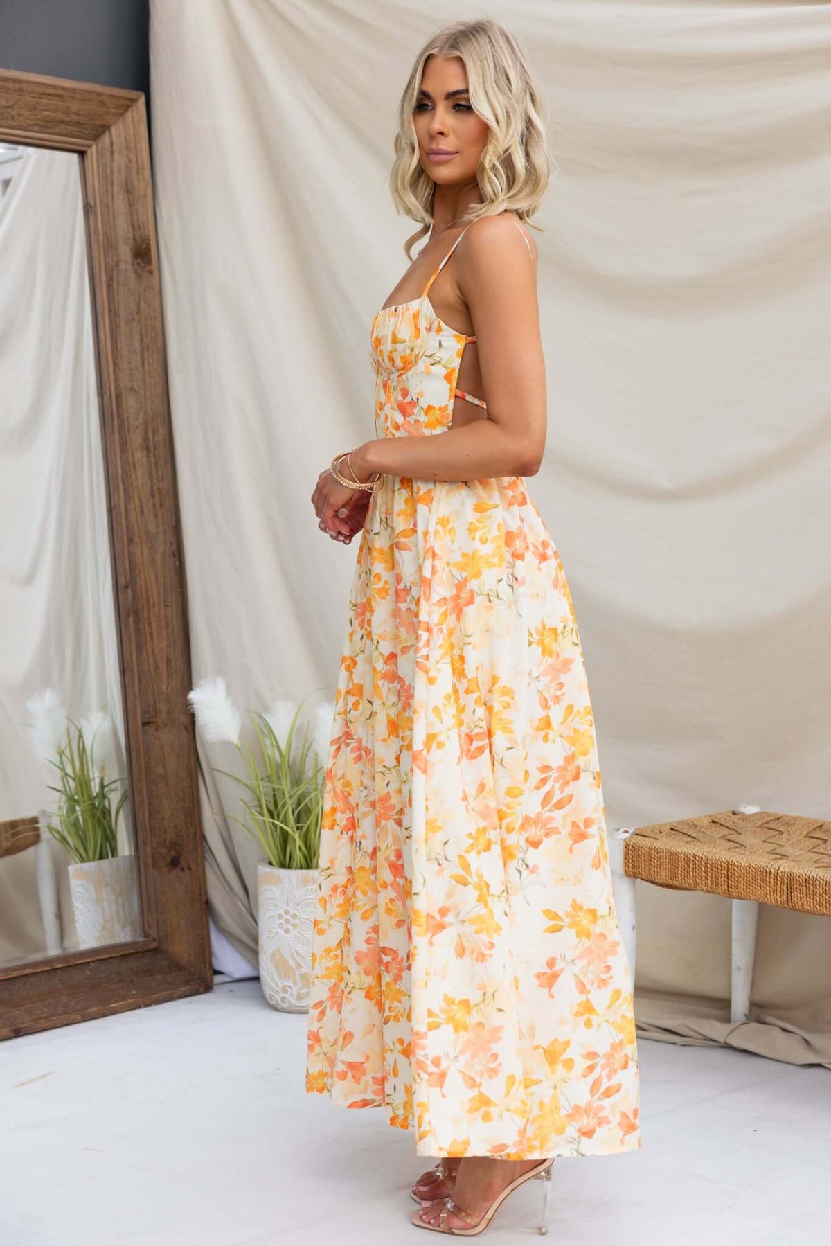 Burkes Midi Dress featuring adjustable tie straps and floral print, perfect for a summer outing.