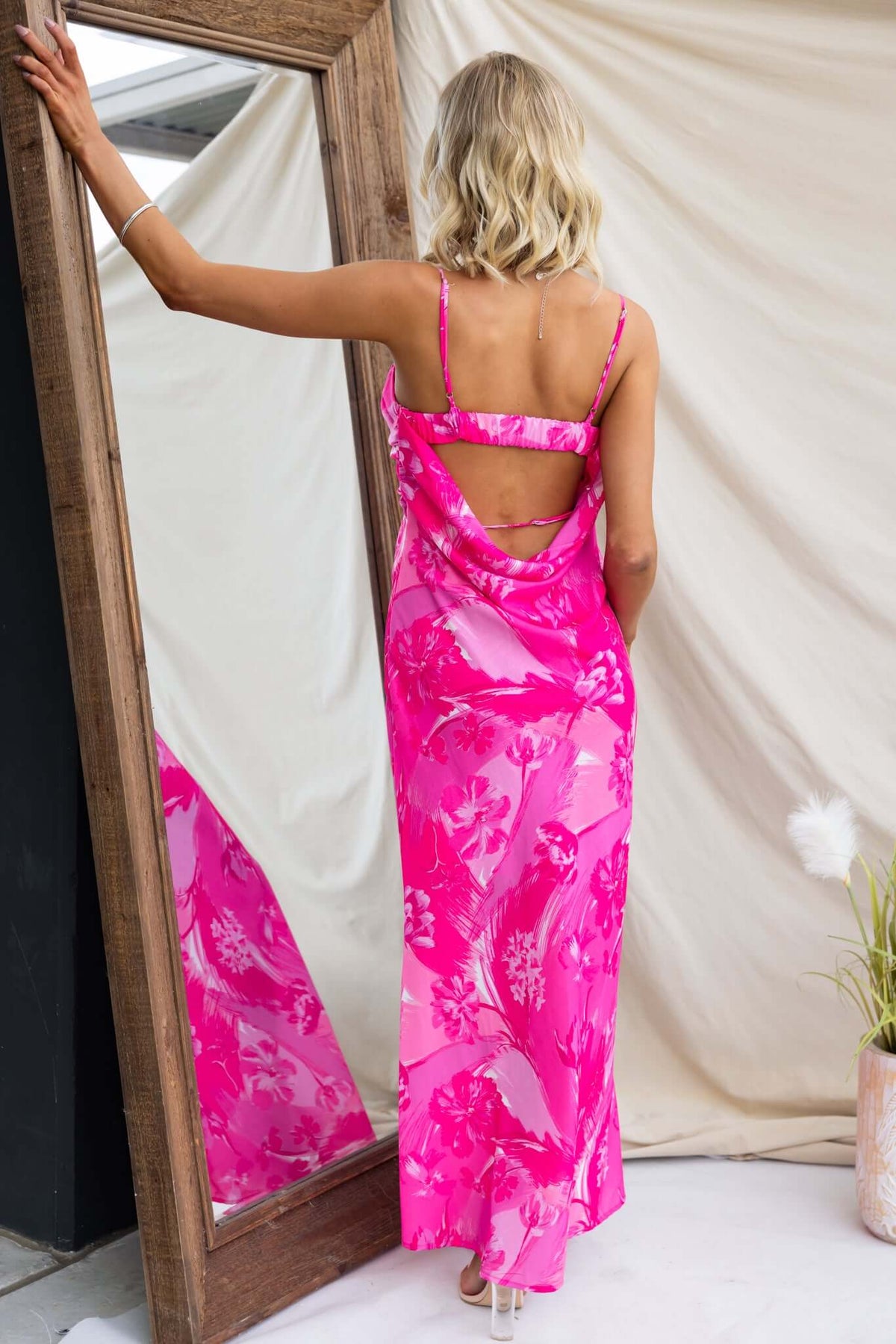 Back view of a model wearing the pink floral Calm Soul Maxi Dress with adjustable straps and cut-out detail.