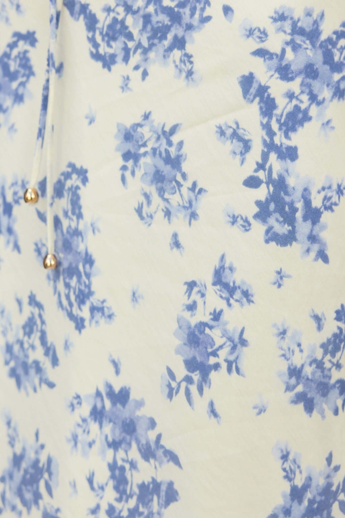 Close-up of blue floral print fabric on Cannon Maxi Dress, featuring delicate flowers on a light background.