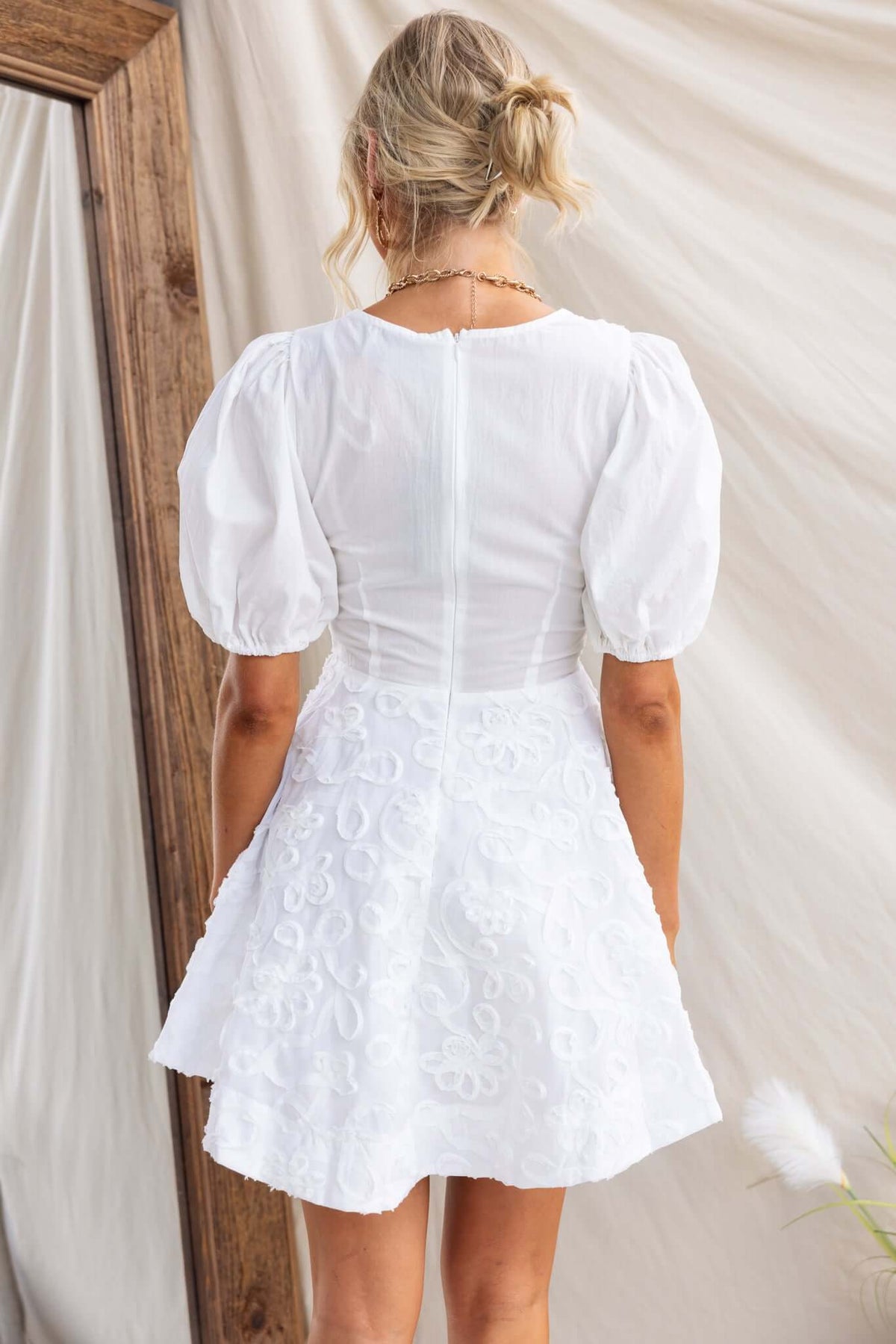 Back view of Casen Dress featuring a V-neckline, puff sleeves, and an invisible zip detail.