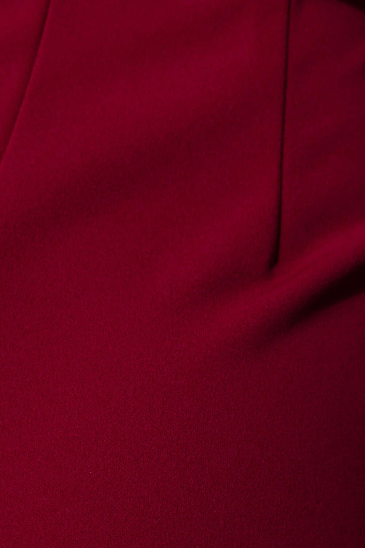 Close-up of rich burgundy fabric showcasing soft texture and tailored details of the Devon Midi Dress.