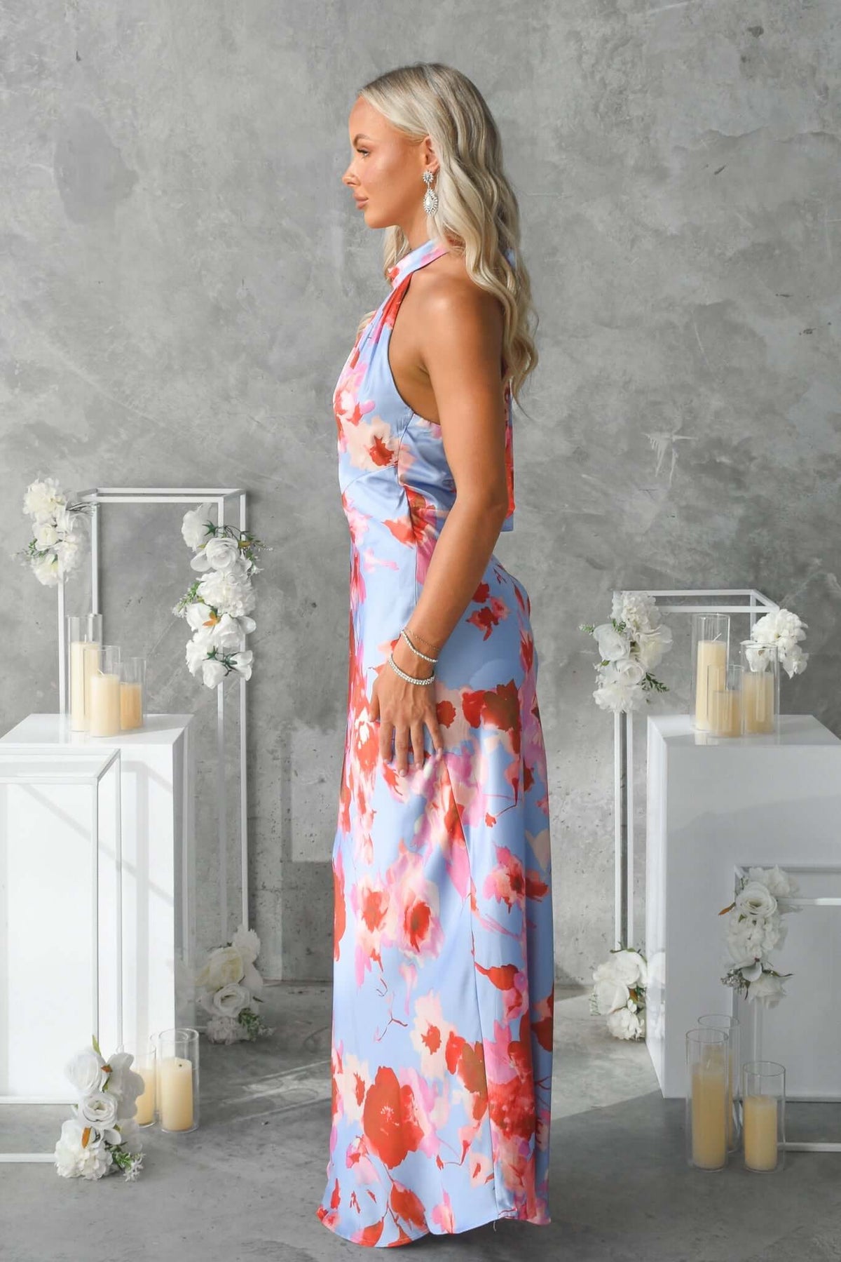 Side view of a model wearing the Forbidden Love Maxi Dress featuring a floral design and high tie neckline.