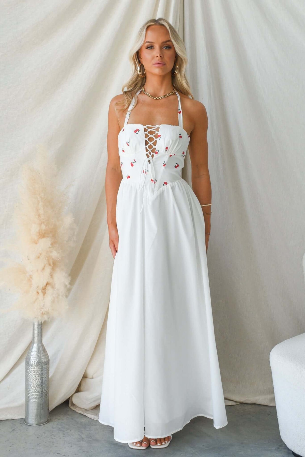 Serefina Maxi Dress featuring tie straps and lace-up bust design, displayed by a model against a neutral backdrop.