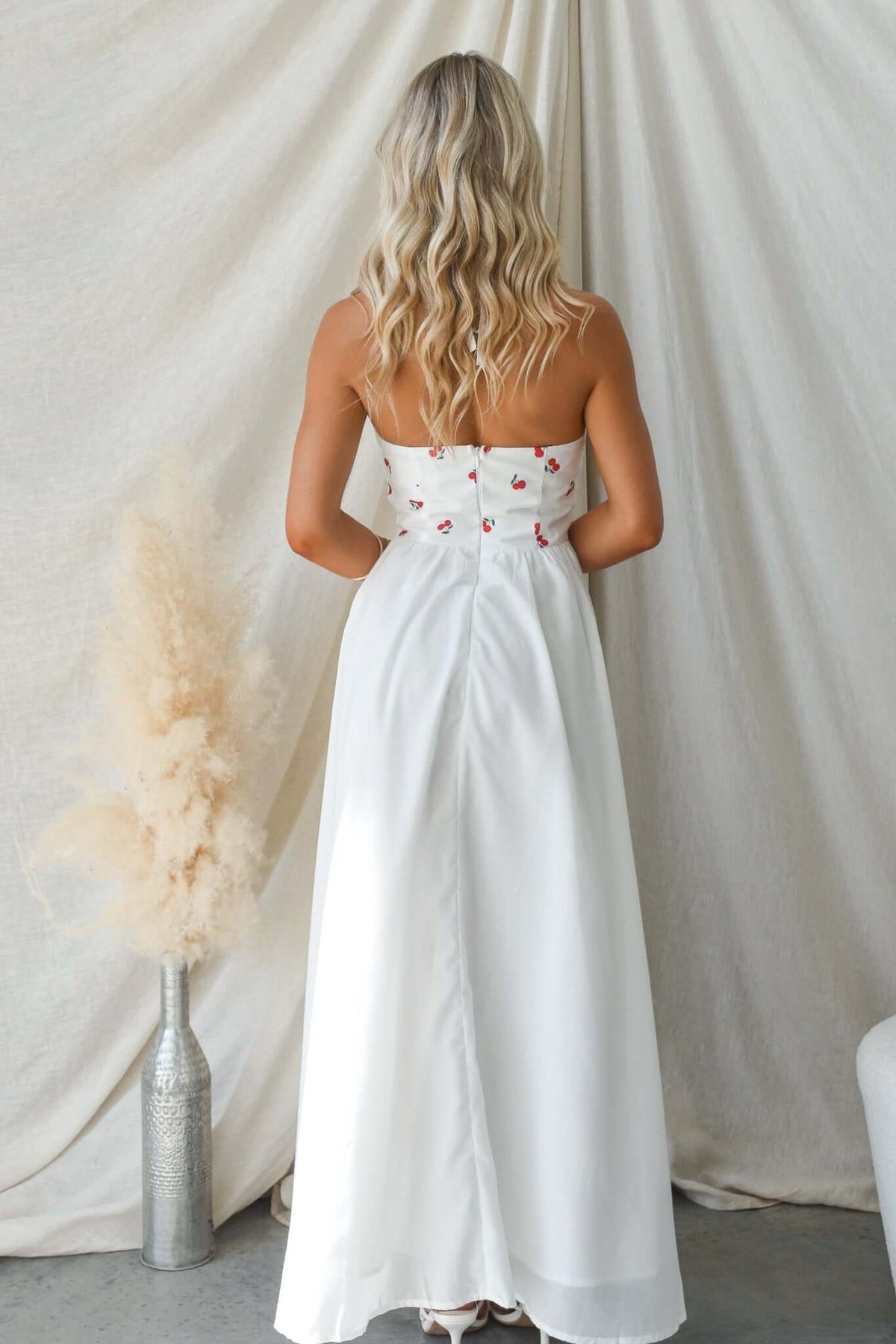 Back view of Serefina Maxi Dress featuring tie straps and floral embroidery, styled with neutral decor.