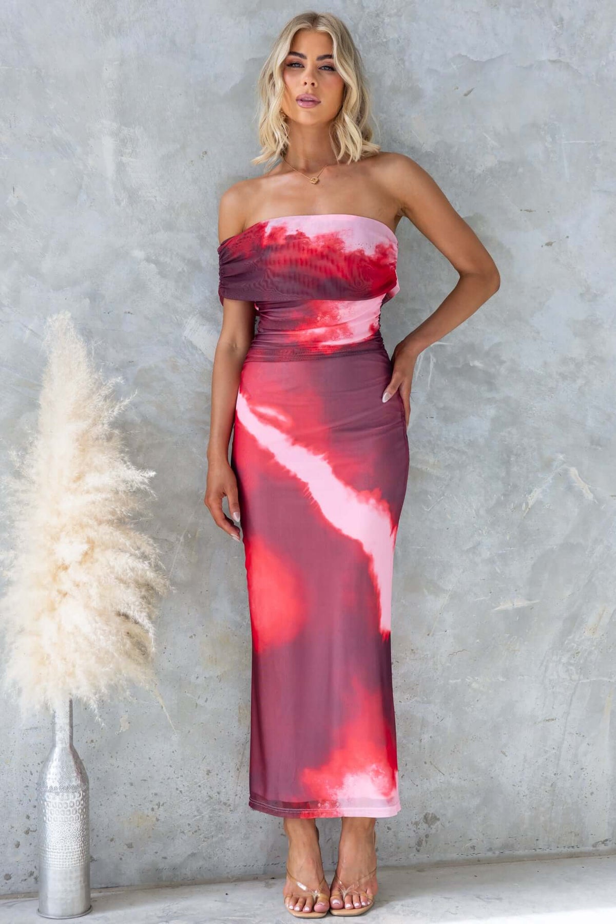 Eccentric maxi dress in pink and red tie-dye with one-shoulder neckline, perfect for summer events.