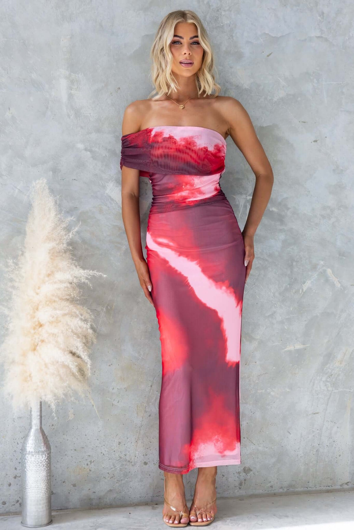 Eccentric maxi dress featuring a one-shoulder neckline, mesh material, and a vibrant red tie-dye design.