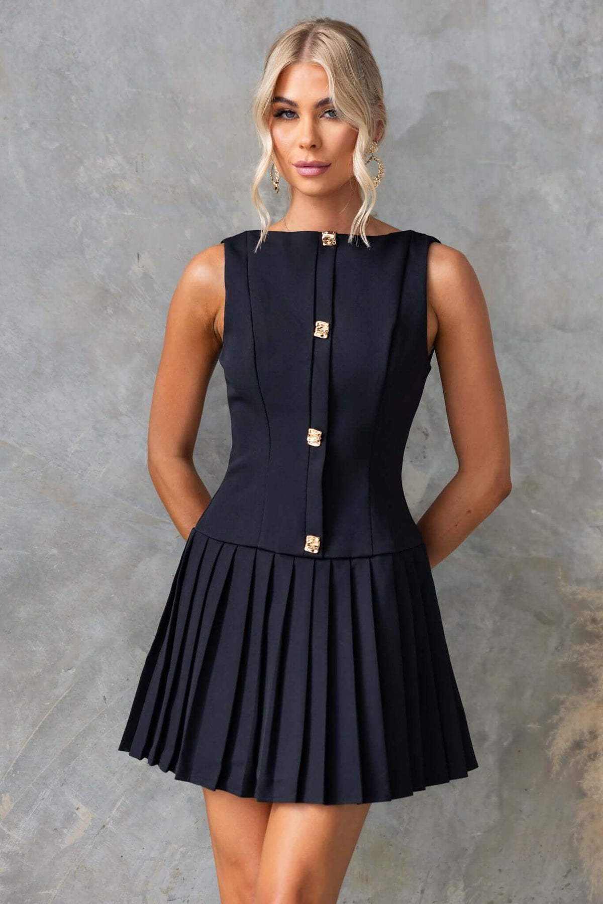 Empoli Dress featuring high neckline, faux buttons, pleated skirt, and lined design in black color.
