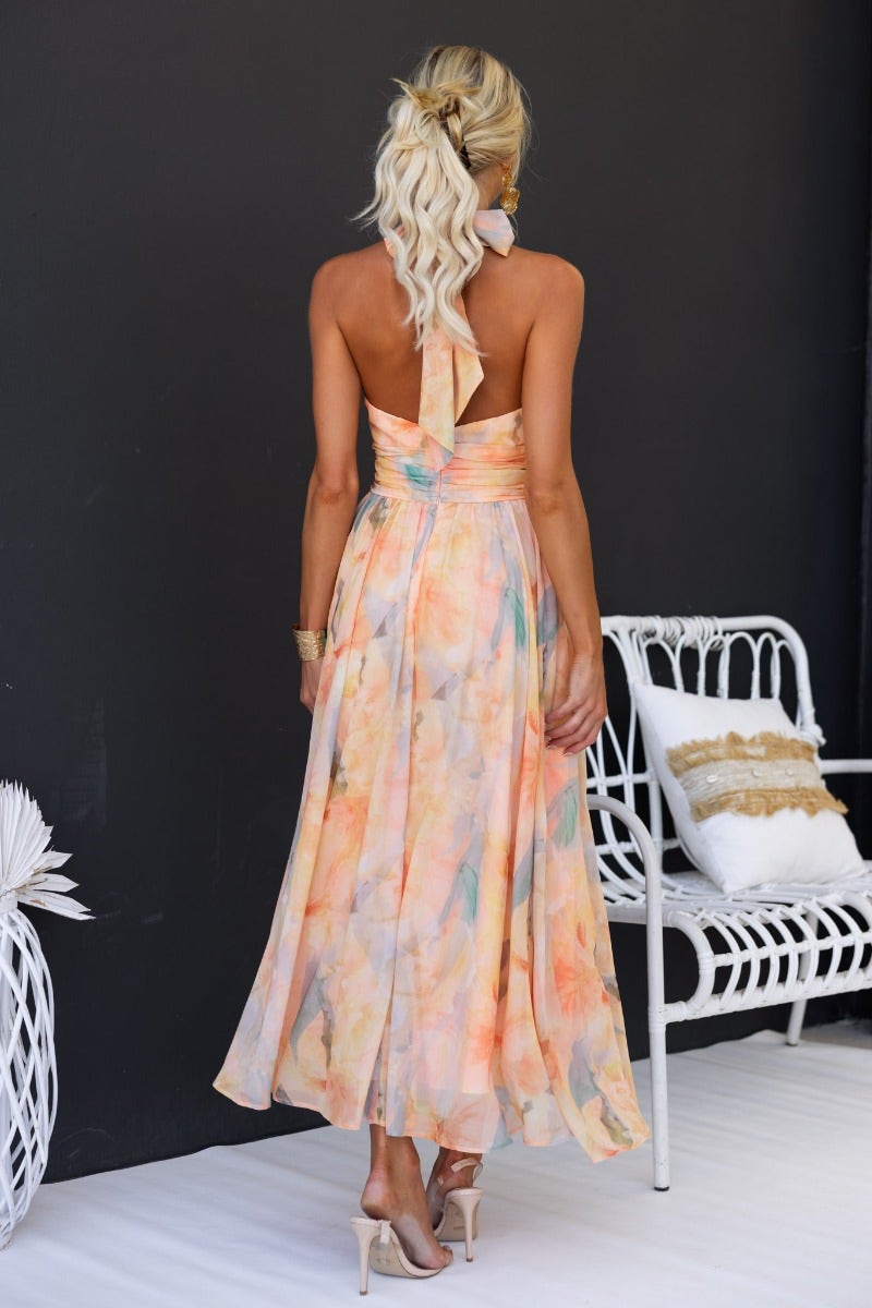 Back view of the Little Things Maxi Dress featuring a floral print, high tie neckline, and flowing design.