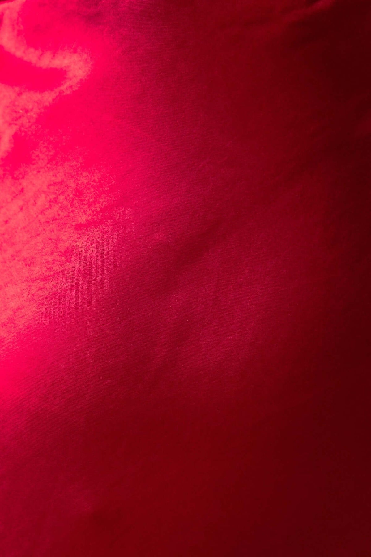 Close-up of rich red satin fabric showcasing a smooth texture, perfect for a stylish maxi dress design.