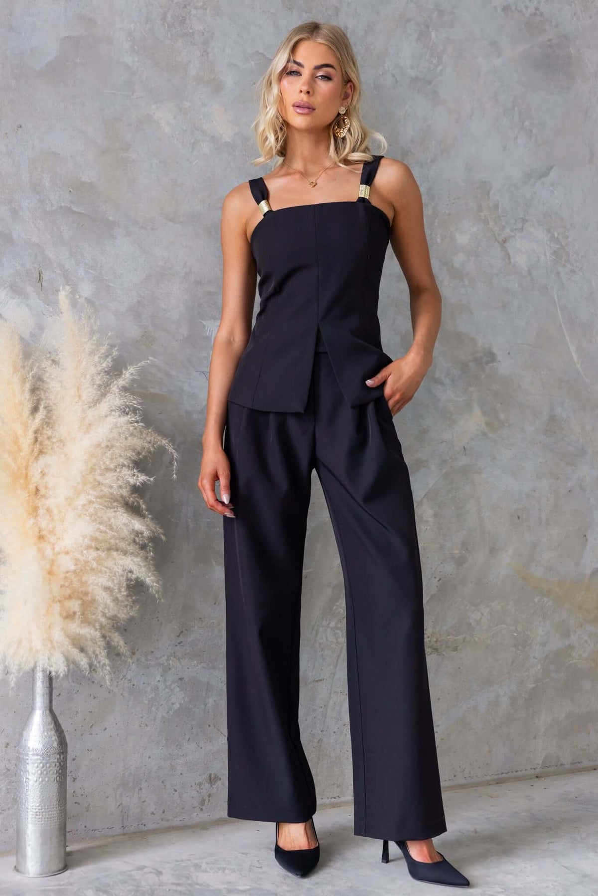 Gette Pants worn by model, featuring a mid-high waist fit, pockets, made from 100% polyester for comfort.