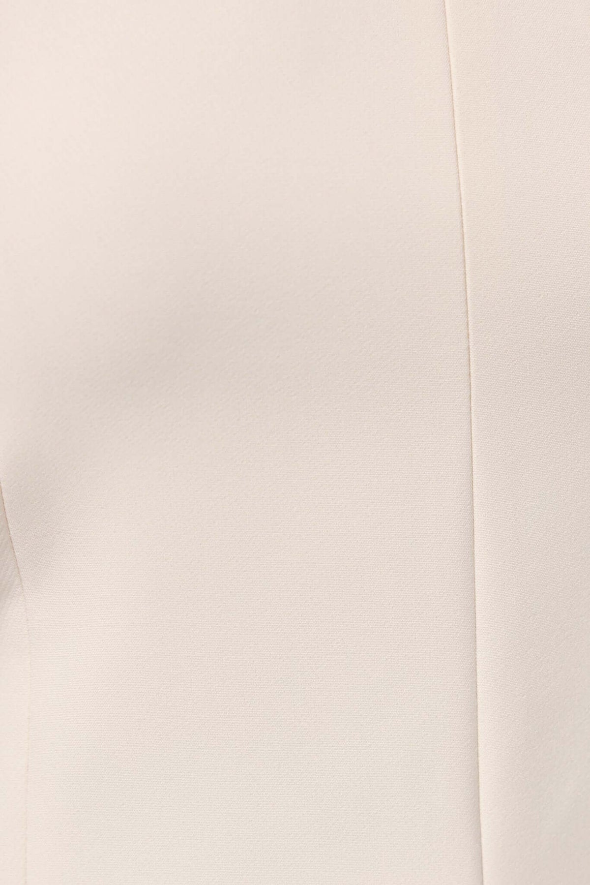 Close-up of Gette Top showing the lined fabric, zip at back, and split at front. Adjustable straps in a neutral color.