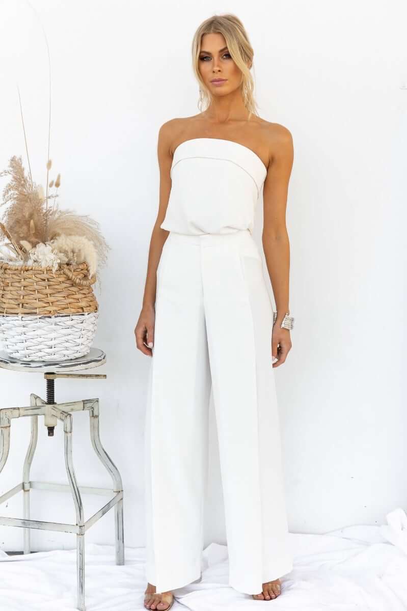 Model wearing high waist Hampton Style Pants with flared bottom and pockets, paired with a strapless top, styled elegantly.