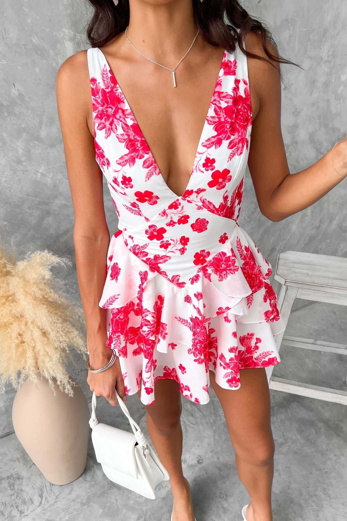 By Your Side Playsuit with floral design, adjustable straps, and layered ruffle skirt, styled on a model.