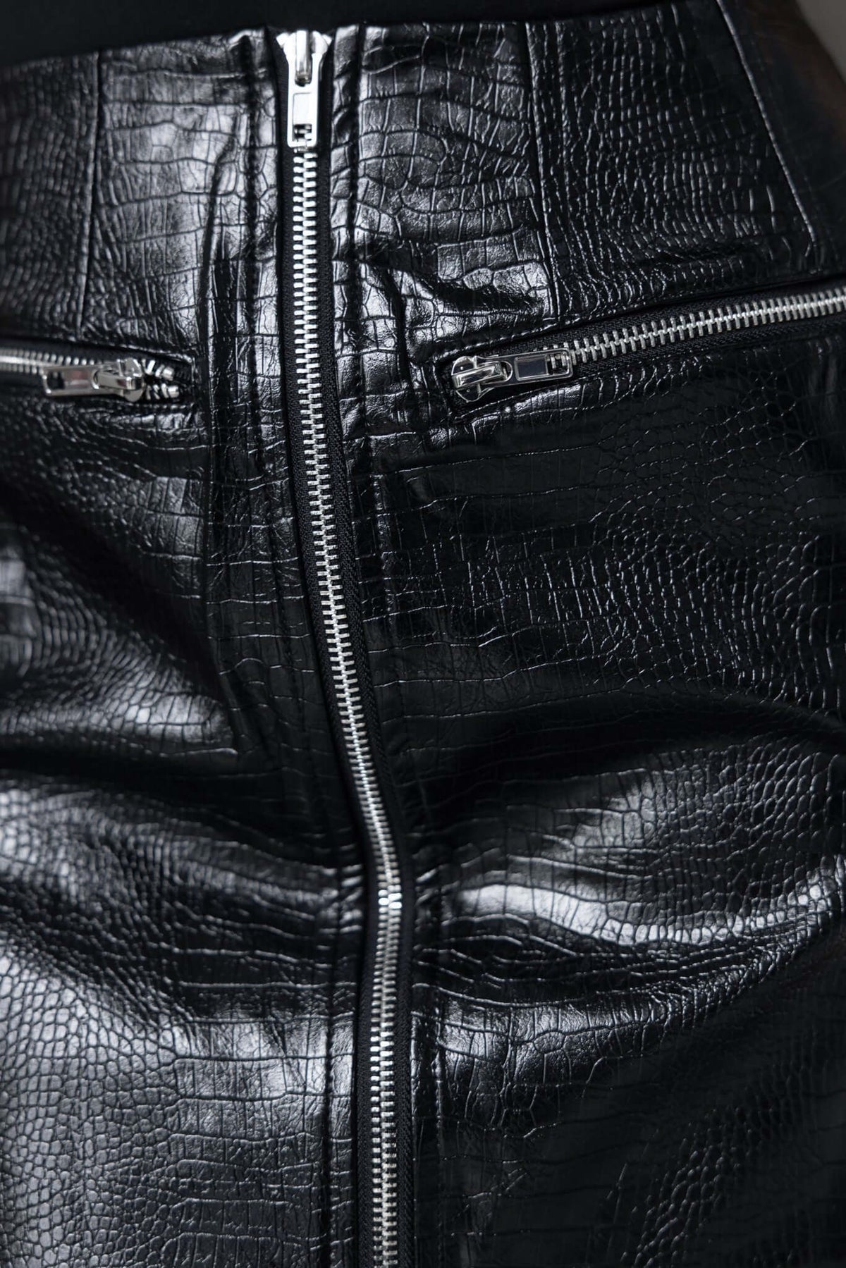 Close-up of the Intense Skirt in faux leather with a zip front and faux pockets, showcasing a mid-high waist fit.