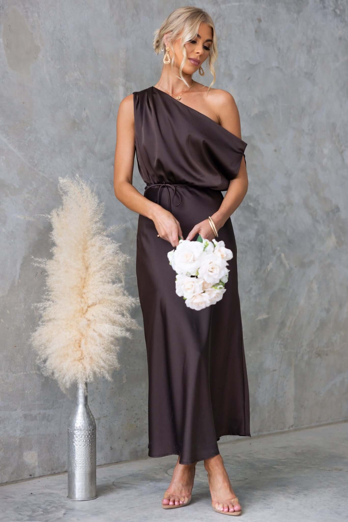 Issey Maxi Dress features an asymmetric neckline, satin fabric, and a removable tie, styled elegantly for any occasion.