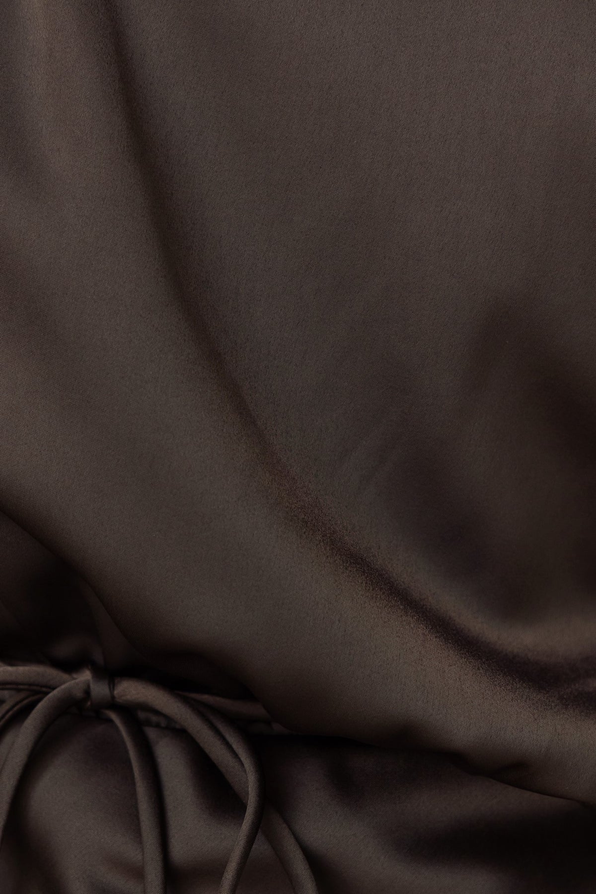 Close-up of the satin material of the Issey Maxi Dress, showcasing the rich brown color and fabric tie detail.