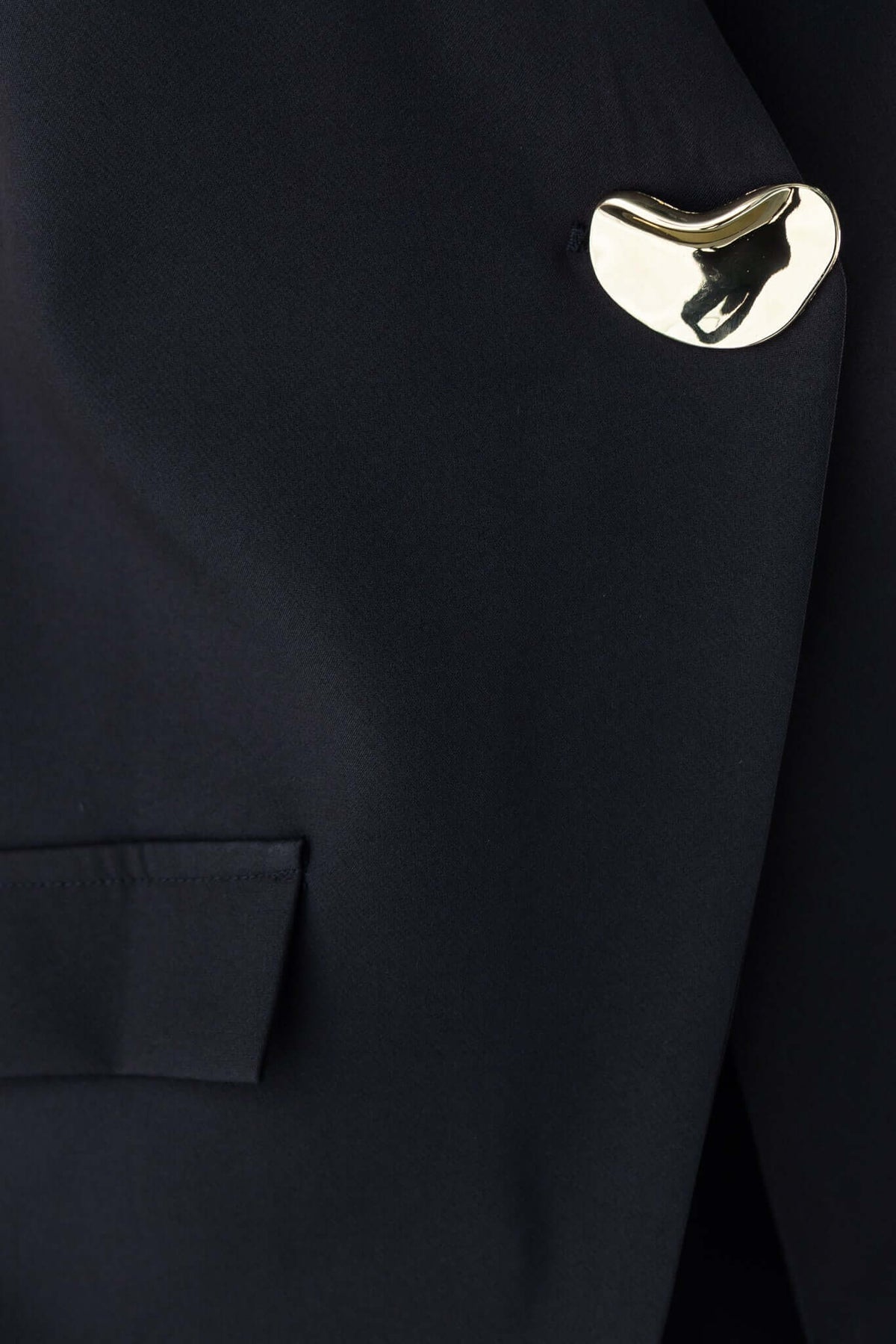 Close-up of a stylish navy fabric featuring a unique gold accent on the pocket.