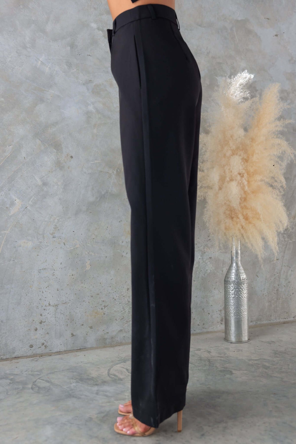 Black mid-high waist Josefina Pants in a side view, showcasing a non-stretch fit, styled with a minimalist backdrop.