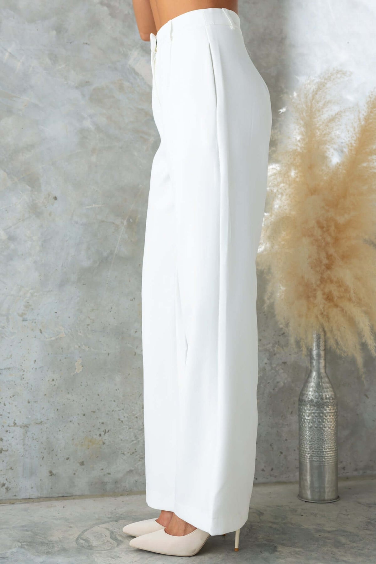 Profile view of Josefina Pants, mid-high waist fit, lined, non-stretch, elegant white trousers styled with heels.