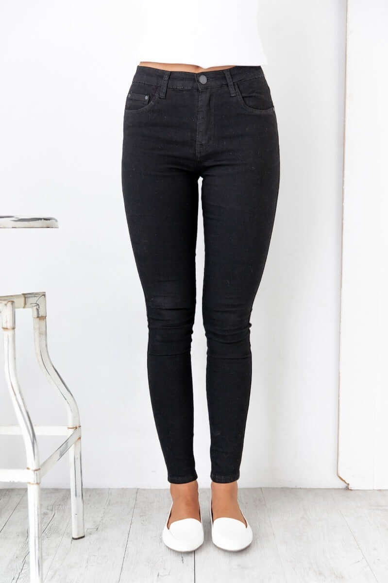 Skinny fit black Justified Jeans with mid-high waist and pockets, made from firm stretch cotton blend.